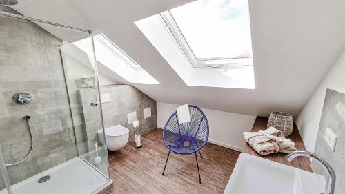 uma casa de banho com uma clarabóia, um chuveiro e um espelho. em Penthouse im Dachgeschoss em Sonthofen