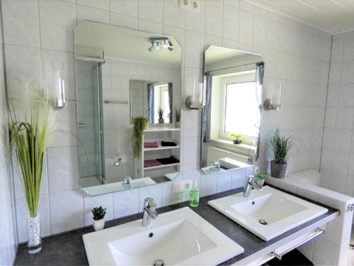 a bathroom with two sinks and a large mirror at Ferienwohnung Hopfinger in Hohenau