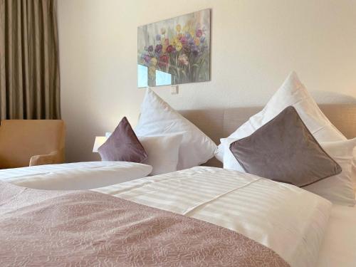 a bedroom with two beds with pillows and a painting at Haus Nordseekrabbe in Greetsiel