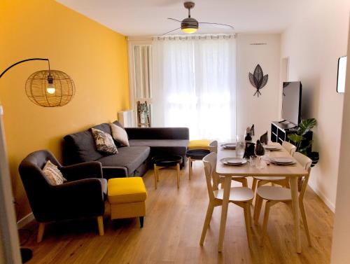 un salon avec un canapé et une table dans l'établissement Rives Occitanes, Appartement Toulouse Purpan, à Toulouse