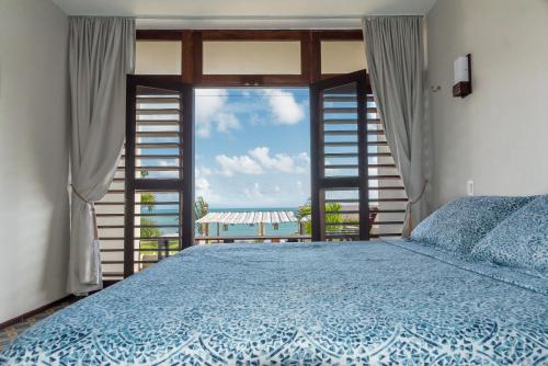 a bedroom with a bed with a view of the ocean at Dolce Vita Guest House in Lagoinha