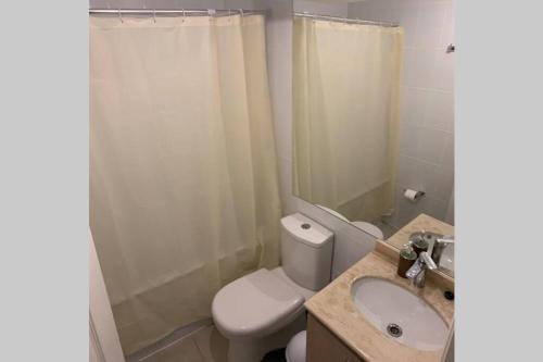 a bathroom with a toilet and a sink and a shower at Acogedor depto en barrio residencial, La Serena in La Serena