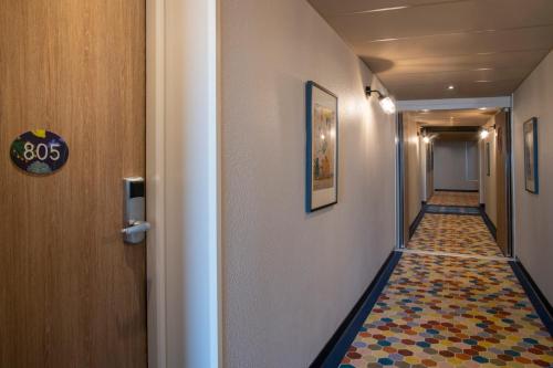 a hallway with a tile floor in a corridor at Novotel Suites Nice Airport in Nice