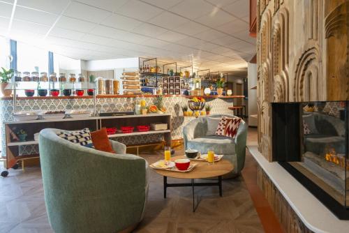 a living room with two chairs and a table at Novotel Suites Nice Airport in Nice