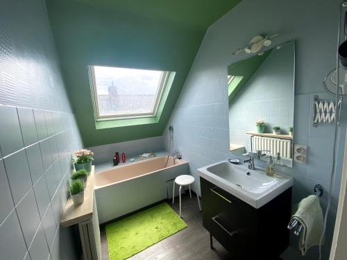 bagno con lavandino, vasca e specchio di B&B Fresco a Ypres