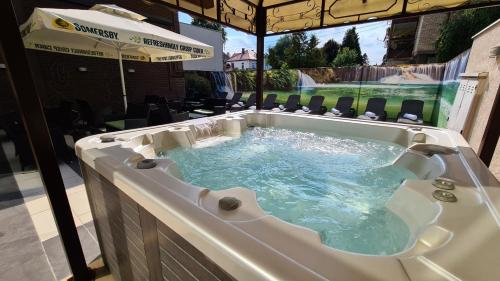 a jacuzzi tub with chairs sitting in it at Hotel Royal Spa in Banja Koviljača