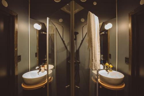 a bathroom with two sinks and two mirrors at Han Sylte Bed and Breakfast in Fauske