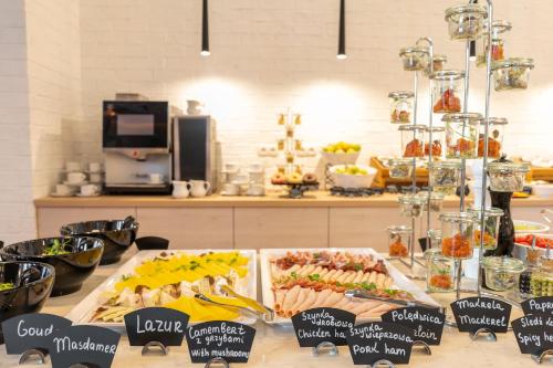 a buffet of food on a table in a kitchen at Grand Focus Hotel Szczecin in Szczecin
