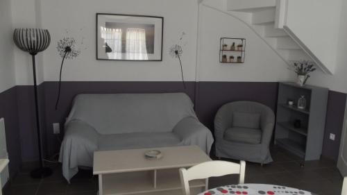 - un salon avec un canapé, une chaise et une table dans l'établissement Les Pluviers en Baie, à Saint-Valery-sur-Somme