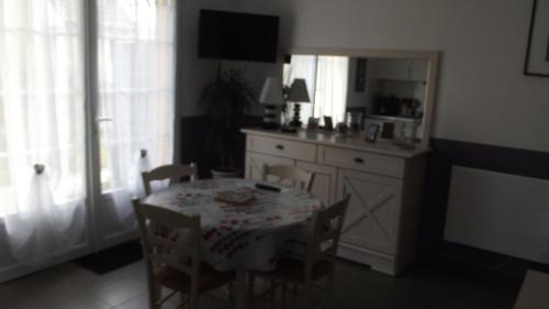 comedor con mesa y sillas y cocina en Les Pluviers en Baie, en Saint-Valery-sur-Somme
