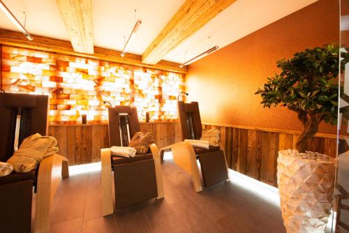 a room with a bunch of chairs and a plant at Wellness-Hotel ADLER in Bad Wörishofen
