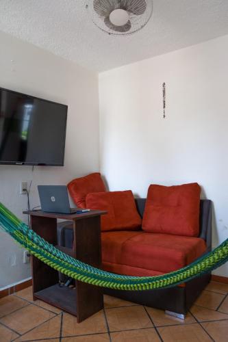 a living room with a couch and a television at Casa Lomas del Marinero Internet Starlink SIN GARAJE in Puerto Escondido