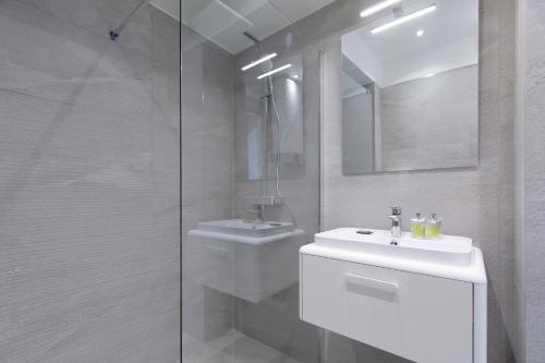 une salle de bain blanche avec un lavabo et une douche dans l'établissement Maison Bianchi - Herold, à Nice