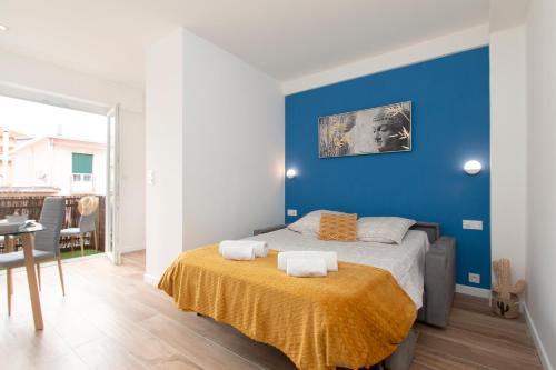 une chambre avec un lit avec un mur bleu dans l'établissement Maison Bianchi - Herold, à Nice