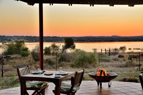 a table and chairs and a fire pit on a patio at Kameeldrift Waterfront Estate & Resort in Brits