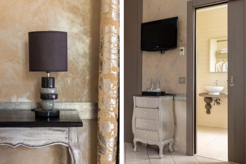 baño con TV y mesa con lámpara en Hotel Royalmar, en Cagnes-sur-Mer
