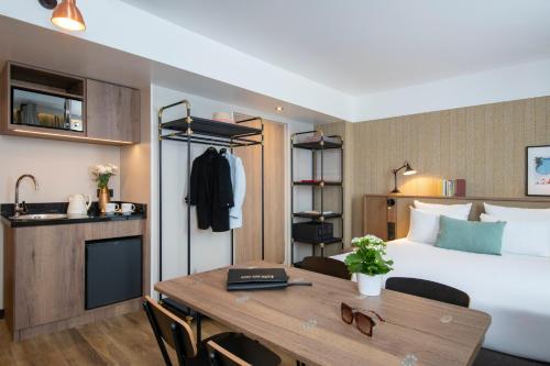 a hotel room with a bed and a desk at Novotel Suites Nice Airport in Nice