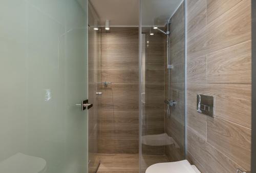 La salle de bains est pourvue de toilettes et d'une douche en verre. dans l'établissement Margiani Studio, à La Canée