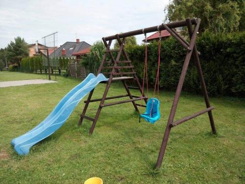 einen Spielplatz mit einer blauen Rutsche und einem blauen Stuhl in der Unterkunft Pokoje Gościnne Grzybowo in Grzybowo