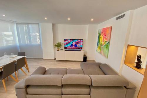 a living room with a couch and a tv on a wall at Central Modern Apartment 3 bed 2 bath in El Campello
