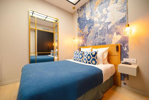 - une chambre avec un lit et une peinture murale dans l'établissement Résidence du Louvre, à Paris