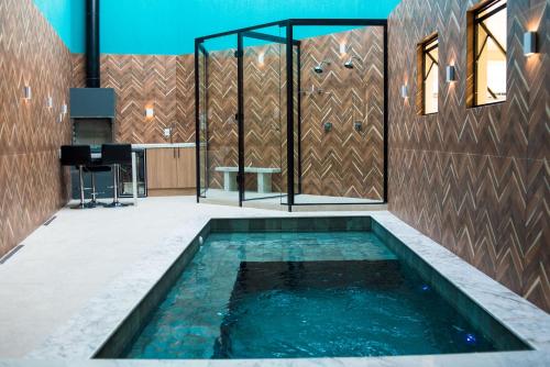 a swimming pool in the middle of a house at Villages Motel by Drops in Lages