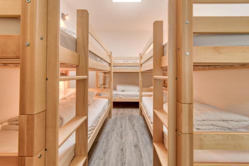 a group of bunk beds in a dorm room at À 80m des pistes, bel appartement pour 15 in Génos