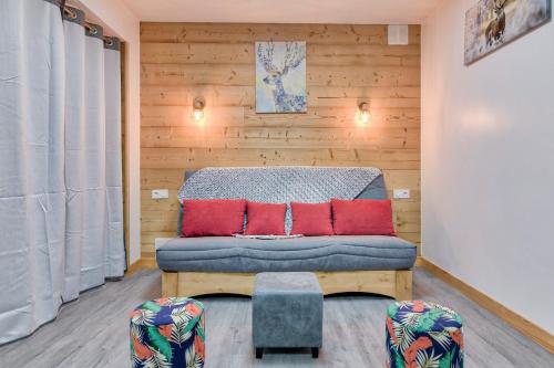 a bedroom with a bed with red pillows at À 80m des pistes, bel appartement pour 15 in Génos