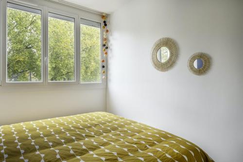 a bedroom with a bed and two windows at MANGIN appartement moderne et chaleureux au coeur de Nantes in Nantes