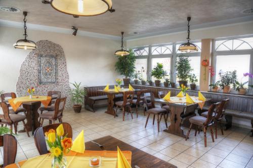 a restaurant with tables and chairs and windows at Pension & Gasthaus Kahren in Kahren