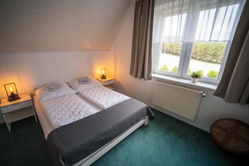 Una cama o camas en una habitación de Dom na wzgórzu z widokiem na jezioro z balią i sauną
