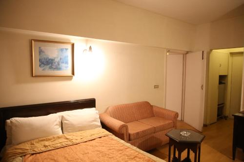 Habitación de hotel con cama y silla en Carlton Tower Hotel Lahore, en Lahore