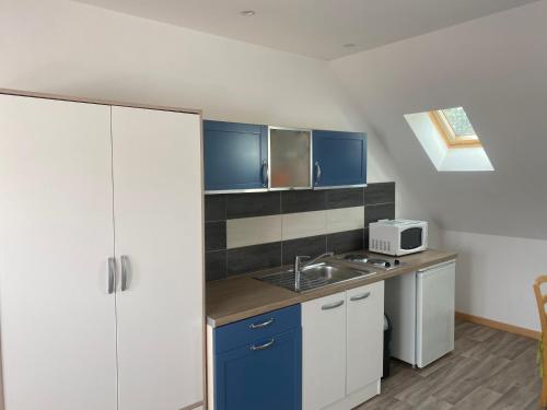 une petite cuisine avec un évier et un micro-ondes dans l'établissement Studio Vieille Ville, à Boulogne-sur-Mer