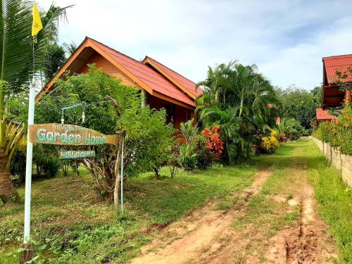 a sign in front of a house on a dirt road at Gardenhomeresortkohjum in Ko Jum