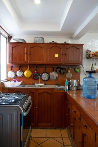 a kitchen with wooden cabinets with pots and pans at Casa Lomas del Marinero Internet Starlink SIN GARAJE in Puerto Escondido