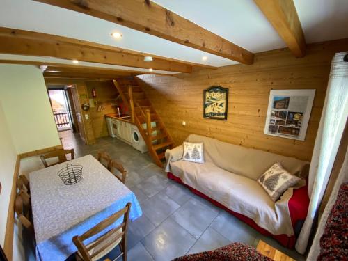 a room with a bed and a table in a house at L ALPIN bel appartement avec terrasse dans vieille ferme de montagne rénovée in Les Orres