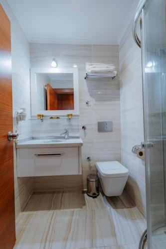 a bathroom with a sink and a toilet and a shower at Kilpa Hotel in Uzungöl