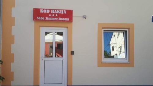 a white building with a door and a window at Sobe Kod Bakija in Karlobag