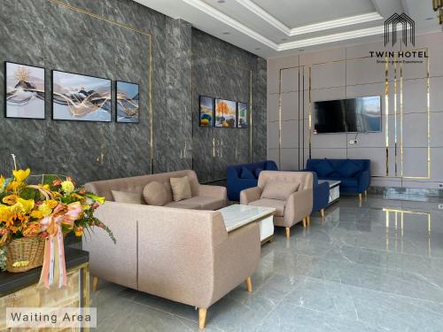 a lobby with a couch and chairs and a tv at Twin Hotel Kampot in Kampot