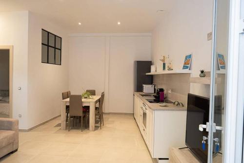 une cuisine et une salle à manger avec une table et une cuisine ainsi qu'une chambre dans l'établissement Casa al Mare a Menton a 100 metri dalla spiaggia, à Menton