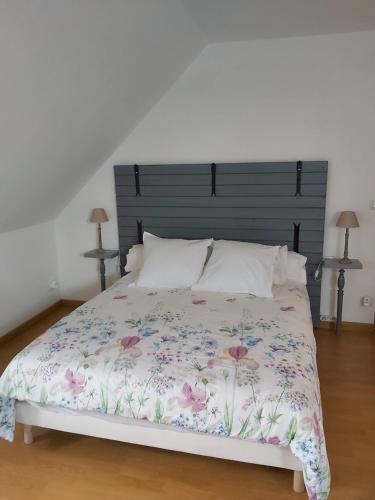a bedroom with a large bed with a floral bedspread at Le R'Epi Normand Chambres d'hôtes et Spa in Ourville-en-Caux