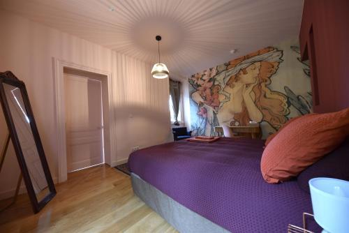 a bedroom with a bed with a painting on the wall at Le Domaine de Dony in Balbins