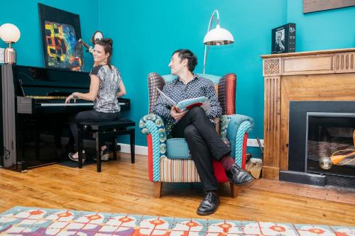 Un uomo e una donna seduti su una sedia con un pianoforte di Le Domaine de Dony a Balbins