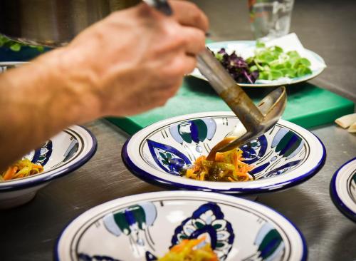 a person using a utensil in a bowl of food at Le Domaine de Dony in Balbins