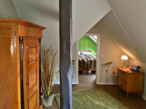 a attic room with a bed and a dresser and a bedroom at Villa Zwölf in Soltau