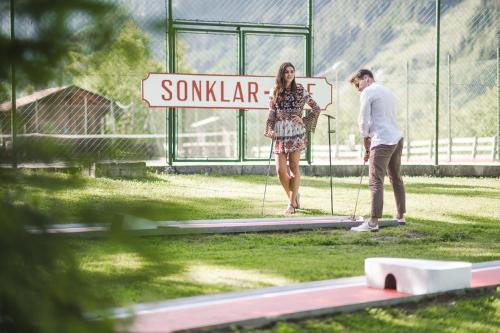 a man and a woman standing on a trampoline at Hotel Sonklarhof in Ridanna