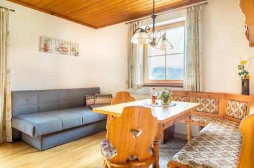 a living room with a table and a couch at Appartement Reitlhof, Bio Berg Bauernhof in Krispl