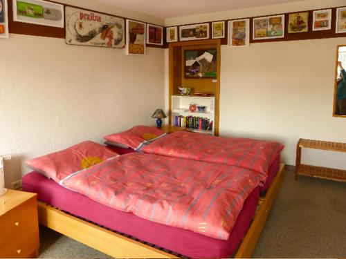- une chambre avec un grand lit et des draps rouges dans l'établissement Ferienwohnung Lehmann, à Lunzenau