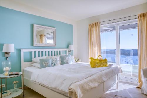een slaapkamer met een wit bed en een raam bij Luxury Villa Malena with private heated pool and amazing sea view in Dubrovnik - Orasac in Zaton