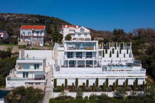 duży biały dom na wzgórzu z domami w obiekcie Luxury Villa Malena with private heated pool and amazing sea view in Dubrovnik - Orasac w mieście Zaton